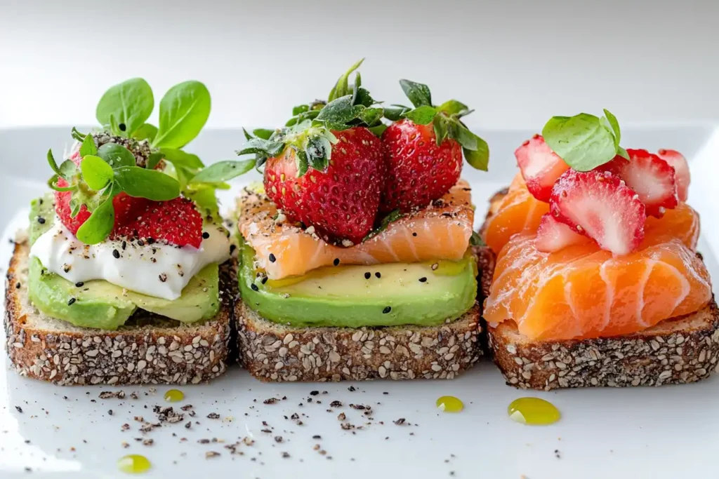avocado toast calories Three Variations One With Greens And Seeds, One With Smoked Salmon, And One With Strawberries And Honey On A Clean, Minimal Plat